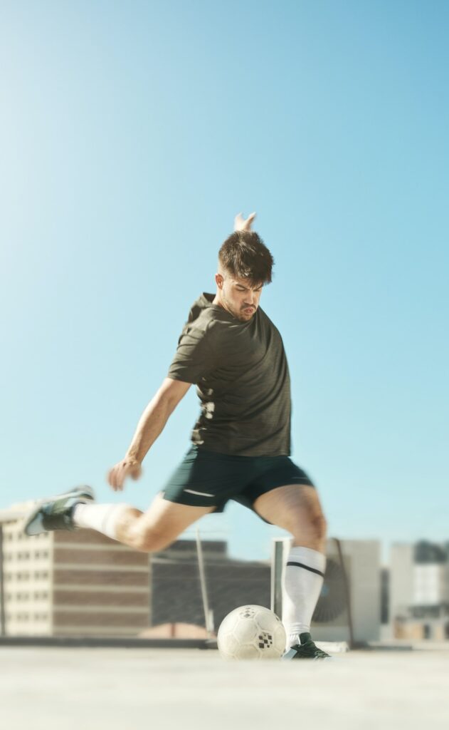 Man, soccer ball and kick in city for goal, shooting or workout on rooftop of building, urban or me